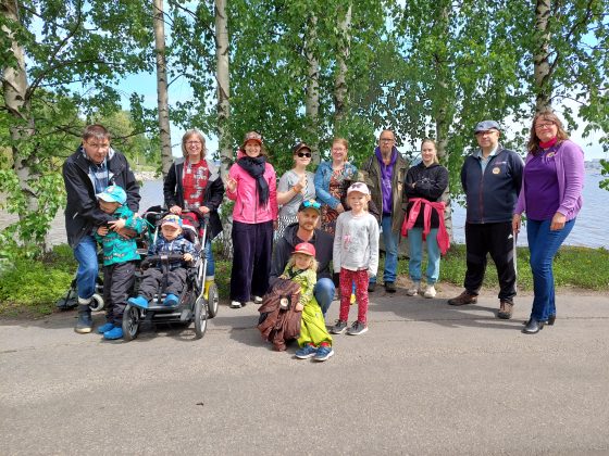 Ryhmäkuva Juniori-ohjelmaan osallistuneista perheistä järven rannalla